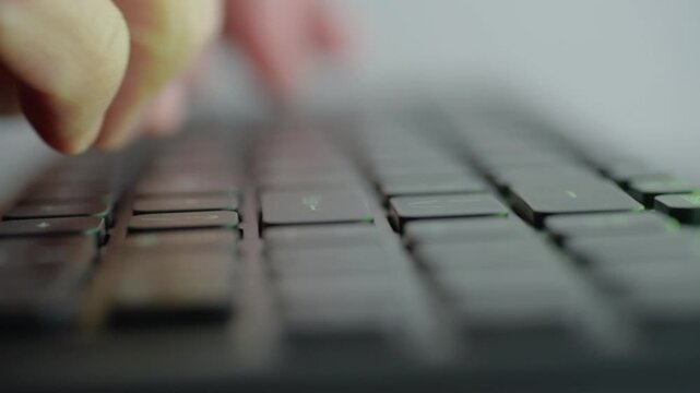 Rapid typing on illuminated keyboard then forceful strike, closeup of hands and fist hitting keys with colored LED spill, intense emotion and release, streamer or gamer tension