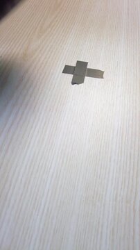 Foot shifting reveals sole placement. Individual transfers weight on wooden surface. Upclose image capturing sole and foot positioning as weight shifts on wooden flooring