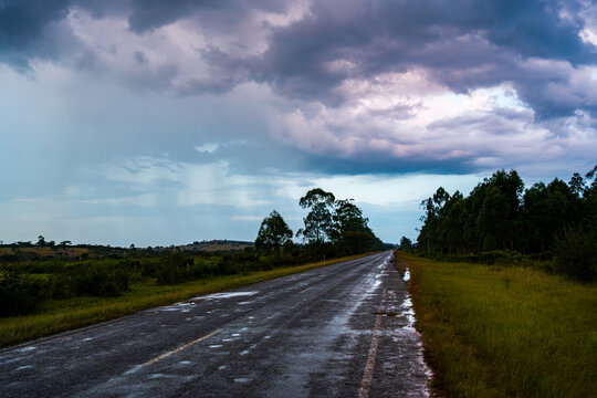 Wet rural road under storm clouds near Mbarara in western Uganda