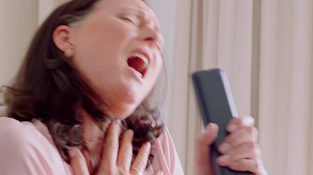 Remote, karaoke and singing with woman in home for musical game, microphone and hobby. Audio performance, song entertainment and happy with mature person and controller in apartment as singer