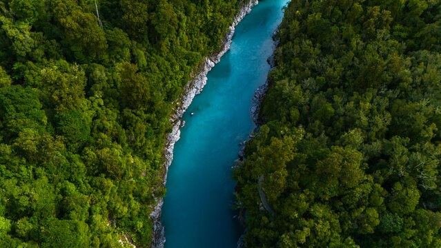 Aerial view of the Hokitika Gorge's turquoise waters winding between the dense, verdant rainforest, a striking contrast of nature's vibrant hues, Hokitika Gorge, New Zealand.