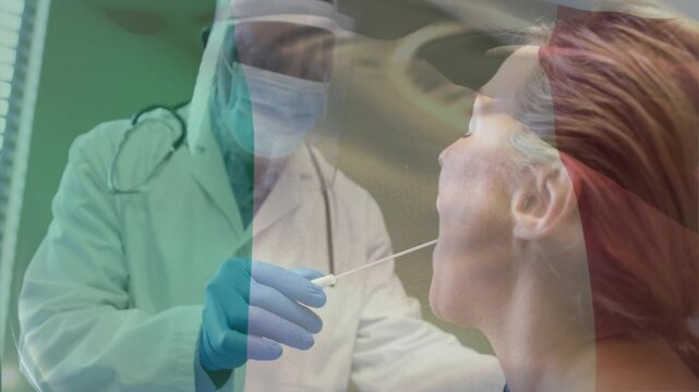 Clinician wearing PPE guiding swab after patient opening mouth for throat testing