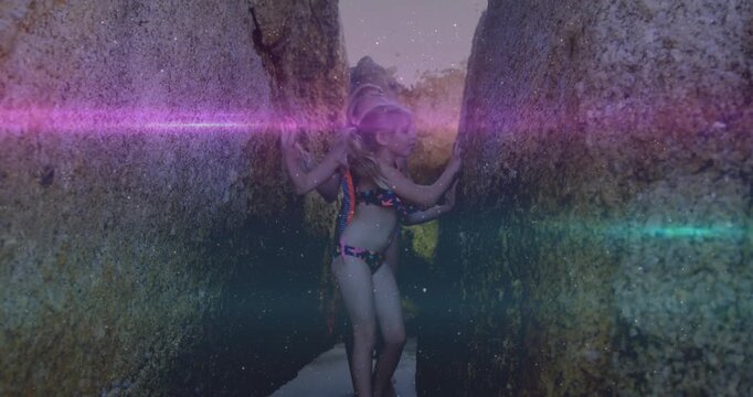 Vertical video: Three kids entering crevice feeling walls moving to opening for travel purple flare