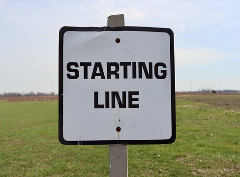 A close view of the black and white starting line sign.