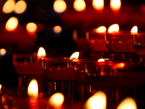 Glowing votive candles with warm golden flames inside Notre-Dame de la Garde basilica Marseille