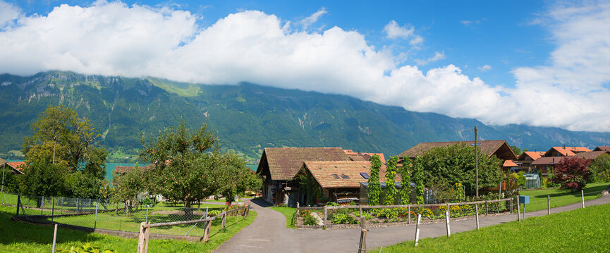 walkway at pictorial village tourist resort Iseltwald, orchard with apple trees. swiss alps