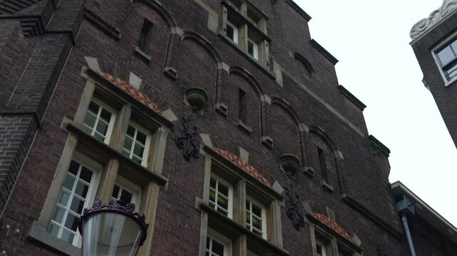 Historic Amsterdam building facade with stepped gable under overcast sky