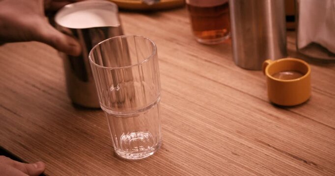 Pouring hot milk into glass for Latte Macchiato in slow motion