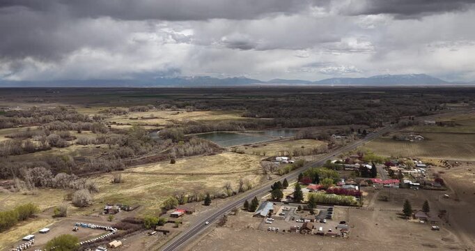 Aerial rural property in Del Norte Colorado along highway 160 in spring time with dramatic sky