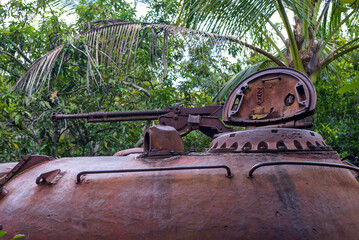 Close-up of a heavily rusted vintage tank turret at an outdoor war museum in Cambodia, with decaying metal surfaces revealing years of tropical weathering and oxidation. © Fabio