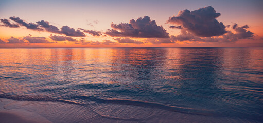 Naklejka na ściany i meble Captivating panoramic tropical ocean waves sunset dramatic sky vibrant purple orange golden clouds reflected calm water serene seascape nature travel background breathtaking coastal evening scenery