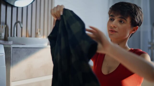 Housewife home work routine examining clean laundry domestic chores closeup