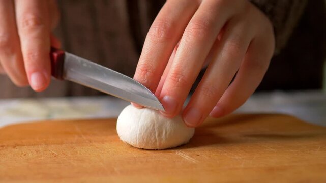 Slicing Fresh Champignon Mushrooms &mdash; Hands Cutting Agaricus bisporus Button Mushroom on Wooden Chopping Board, Home Cooking Food Preparation Video
