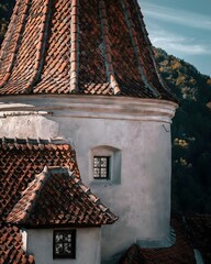 Close-up of medieval tower with red tiled roof and stone walls © Reserved