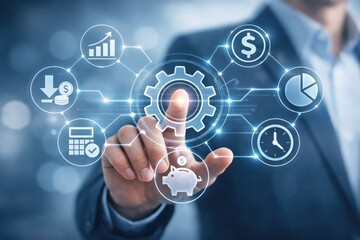 Fototapeta premium Businessman touching a glowing digital interface with gear, financial currency symbols, and data charts in a blue-toned business environment