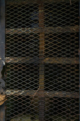 Fototapeta premium Rusted black iron drain cover outdoors with weathered metal texture