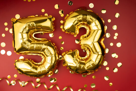 53rd birthday celebration. Gold festive balloons number 53 year anniversary on red background with confetti. Birthday or wedding event.