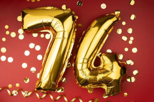 74th birthday celebration. Gold festive balloons number 74 year anniversary on red background with confetti. Birthday or wedding event.