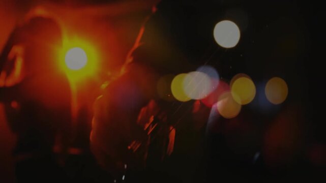 Guitarist silhouette playing electric guitar on dim stage featuring flat design red orange lights