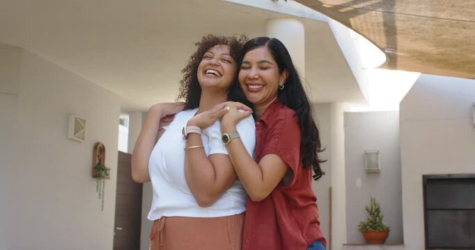 Laughing two women hugging on covered porch, wearing red shirt, white top, watches, hoop earrings
