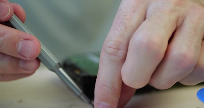Computer repair. Close-up of hands unscrewing circuit board from computer hard drive using screwdriver. Concept of hard drive repair, data recovery, and computer hardware maintenance.
