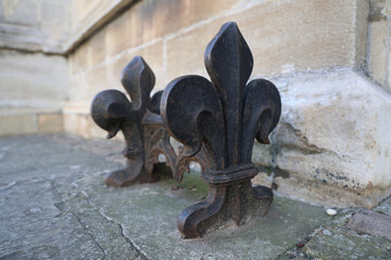 Decorative Fleur‑de‑Lis Boot Scraper Against Historic Stone Wall © Simon