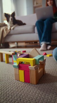Colorful wooden block house stands on carpet during play