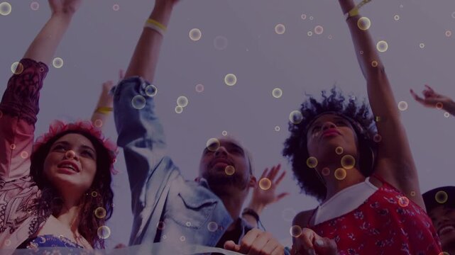 Three adults at railing raising arms, cheering to music, animated bubbles drifting across faces