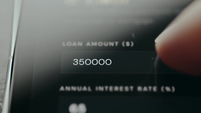 Person using a loan calculator to estimate monthly payments