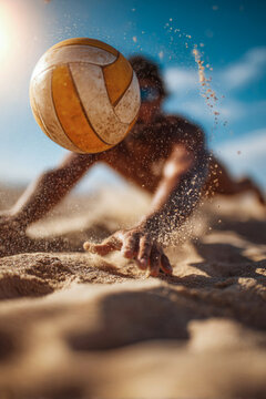 Male beach volleyball player diving to save ball on sandy court under bright blue sky with sunlight illuminating the scene and sand particles in the air