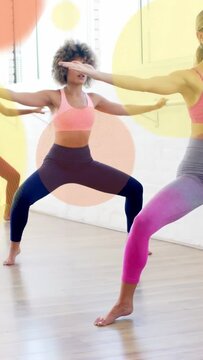 Vertical video: Curly woman holding squat, following coach cueing right arm, fitness dots drifting