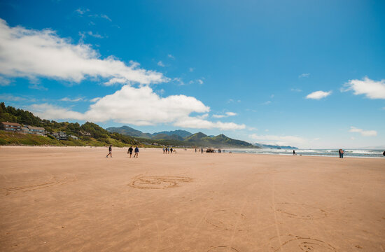 Visitors enjoying a sunny day at Cannon Beach, Oregon.