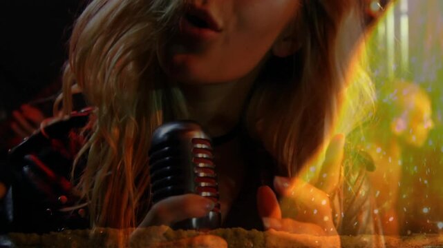 Singer gripping mic starting performance on music stage, guitarist strumming, flame overlay dancing