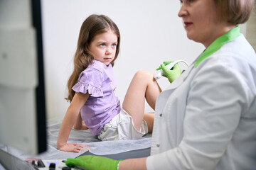 Obraz premium Female child undergoing ultrasound examination in medical room