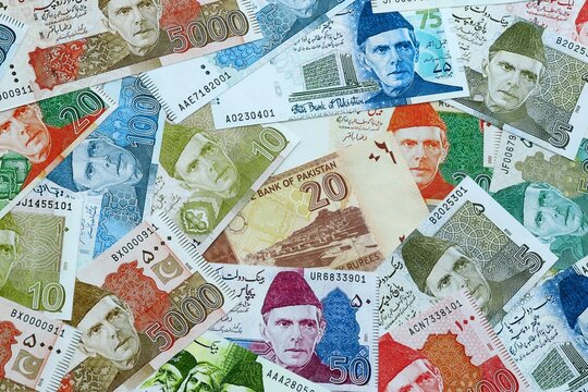 Pakistani rupee money banknotes pile on table. Pakistan bills of PKR currency close up