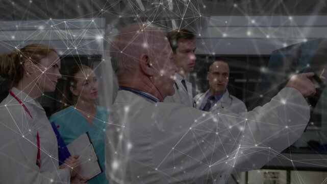 Senior doctor pointing at monitor for diagnosis, team watching as overlay covering screen shifting