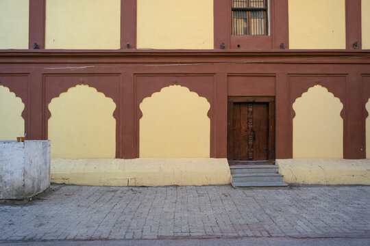Decorative stone carved Arches, Windows & Wooden Door of fort wall of Rajwada, Indore, Madhya Pradesh. Also known as the Holkar Palace or Old Palace. Indian Architecture.