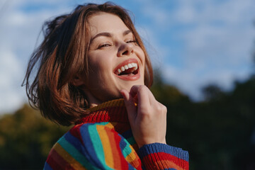 Fototapeta premium Young woman laughing outdoors, striped sweater and short hair bob, sunlight on freckled face, joyful lifestyle portrait in park for fashion, travel and carefree weekend vibes.