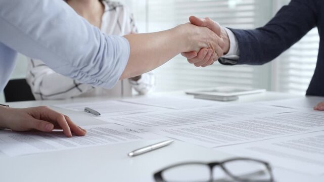Business executives shaking hands, sealing an agreement after successful negotiations in a bright office, symbolizing partnership, collaboration, and a mutually beneficial deal signing
