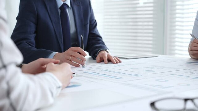 Business professionals discussing legal documents, reviewing mortgage contracts, or signing partnership agreements during an important corporate meeting or consultation session