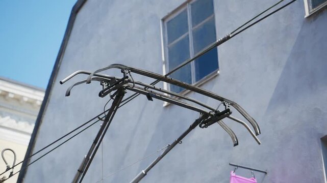 Close up of tram pantograph connecting to overhead electric power lines