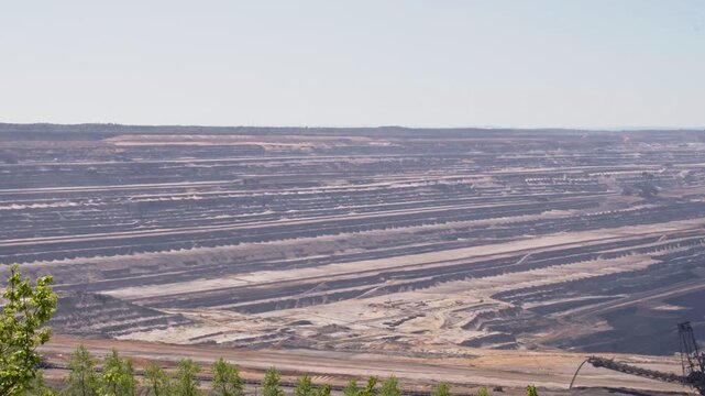 Big quarry with heavy machinery mining lignite coal in open pit min, gathering resources from earth