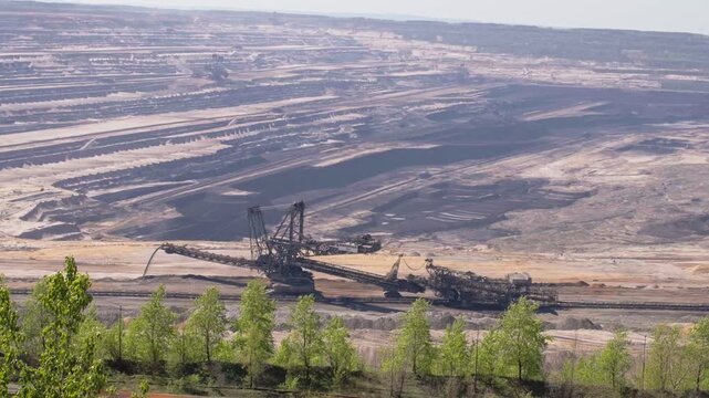 Gigantic spreader heavy machine digging in a vast open-pit lignite mine in Germany