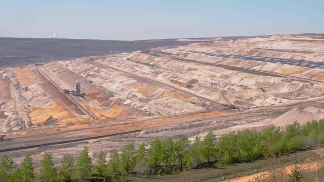 Big quarry with heavy machinery mining lignite coal in open pit min, gathering resources from earth