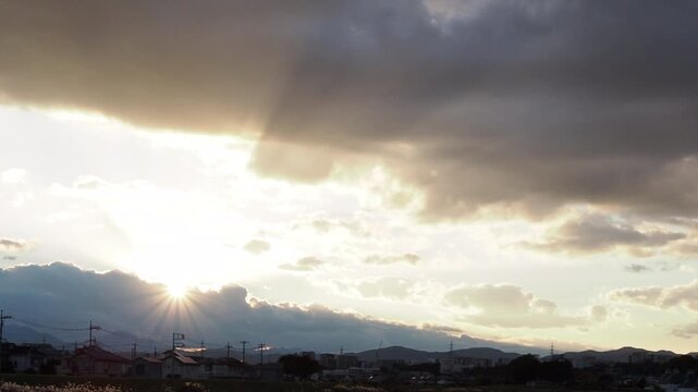 雲の切れ間から射す光と都市の稜線