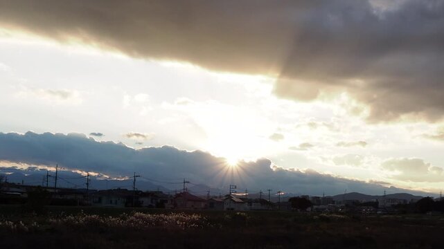 雲の切れ間から射す光と都市の稜線