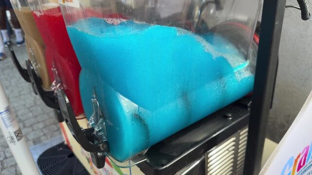 Blue frozen slush drink dispenser with red and tan containers
