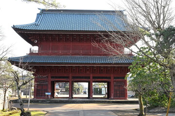 Fototapeta premium 赤い外観が特徴の本成寺の山門（新潟県三条市）