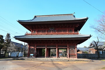 Obraz premium 赤い外観が特徴の本成寺の山門（新潟県三条市）
