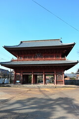 Fototapeta premium 赤い外観が特徴の本成寺の山門（新潟県三条市）